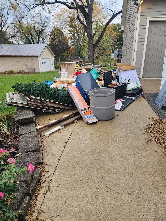 Dumpster being loaded with debris for 12 Yard Dumpster Rental in Frankenmuth